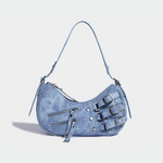 Load image into Gallery viewer, A soft blue denim crescent-shaped shoulder bag featuring buckle straps, zipper embellishments, and silver hardware for a trendy Y2K aesthetic