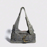 A vintage denim shoulder bag with a zipper closure and shoulder strap, featuring a washed blue color and retro design.