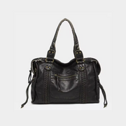 A vintage black leather handbag with gold-tone accents, featuring dual handles and a zipper closure.
